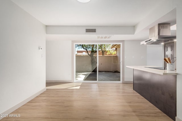 unfurnished dining area featuring light wood-style floors, visible vents, and baseboards