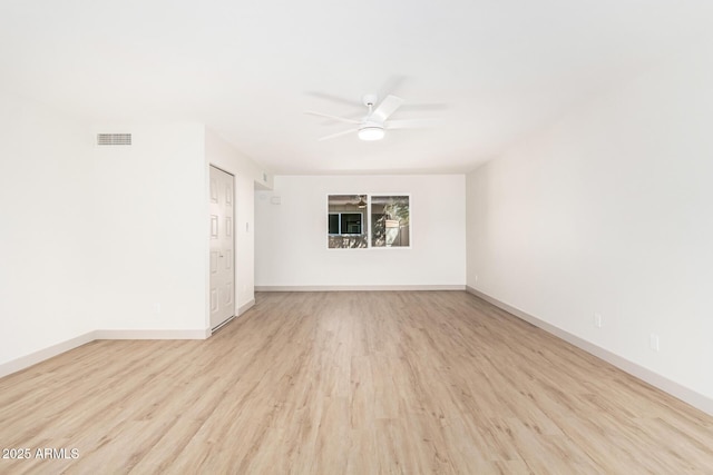 empty room featuring visible vents, wood finished floors, a ceiling fan, and baseboards