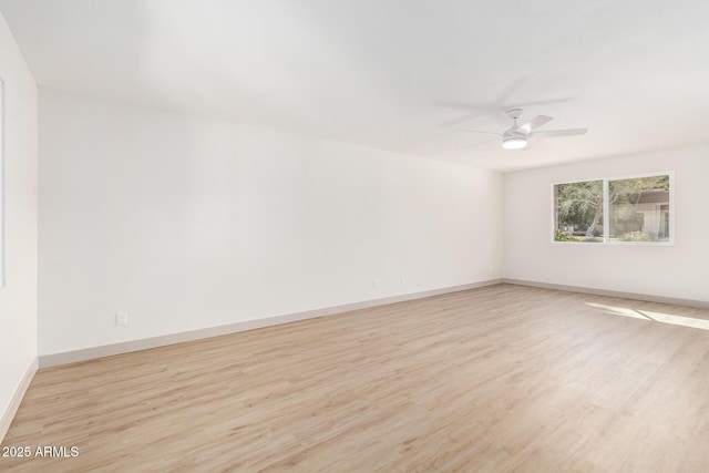 unfurnished room featuring a ceiling fan, baseboards, and wood finished floors