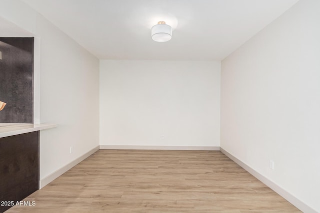 unfurnished room with baseboards and wood finished floors