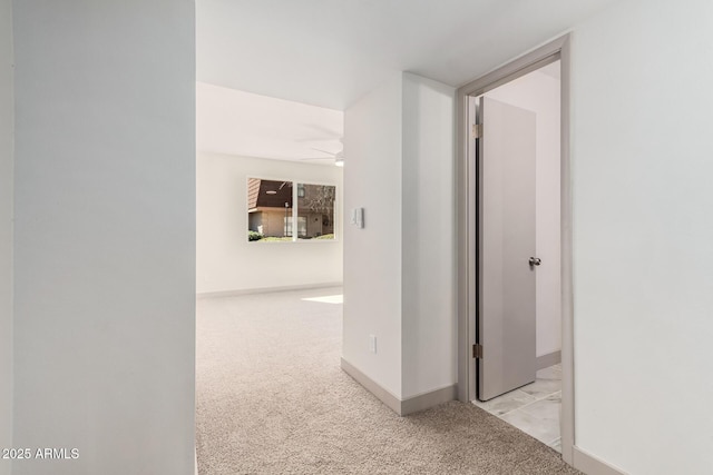 hall featuring light carpet and baseboards