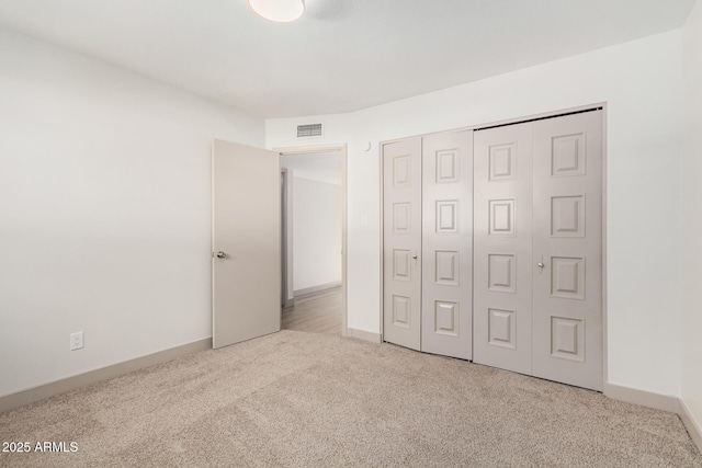 unfurnished bedroom featuring a closet, carpet flooring, visible vents, and baseboards