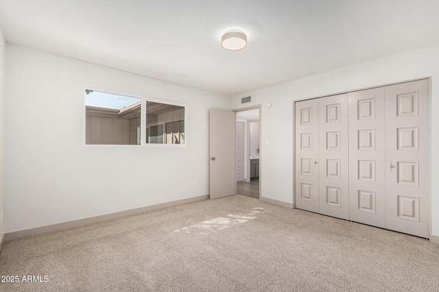 unfurnished bedroom with carpet floors, a closet, visible vents, and baseboards