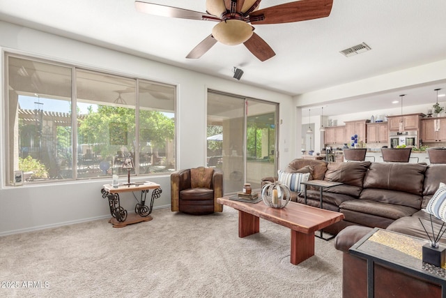 14363 W Acapulco Ln, Surprise, AZ 85379 - living room featuring light colored carpet, visible vents, baseboards, and a ceiling fan
