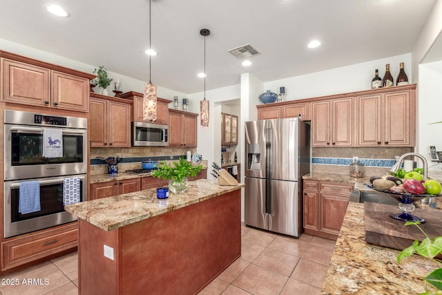 14363 W Acapulco Ln, Surprise, AZ 85379 - kitchen featuring visible vents, stainless steel appliances, a center island, and light tile patterned floors