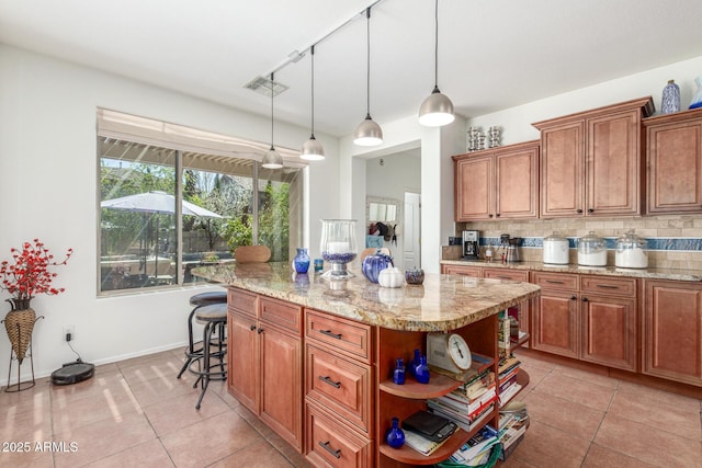 14363 W Acapulco Ln, Surprise, AZ 85379 - kitchen featuring light tile patterned flooring, brown cabinets, backsplash, and light stone counters