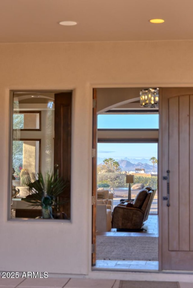 foyer entrance with recessed lighting, a mountain view, and a chandelier