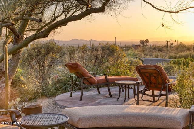 patio terrace at dusk featuring a mountain view