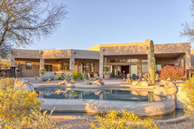 rear view of property with an outdoor pool, outdoor dry bar, and a patio area