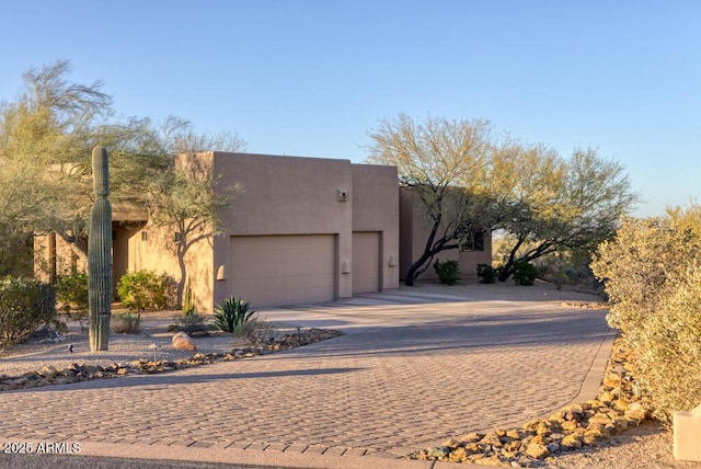 view of front of home featuring a garage, driveway, and stucco siding