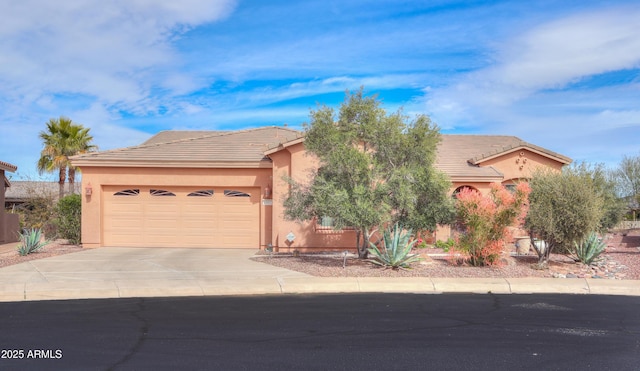 view of front of property with driveway, an attached garage, a tile roof, and stucco siding