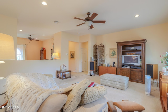 living area featuring ceiling fan, visible vents, light colored carpet, and recessed lighting