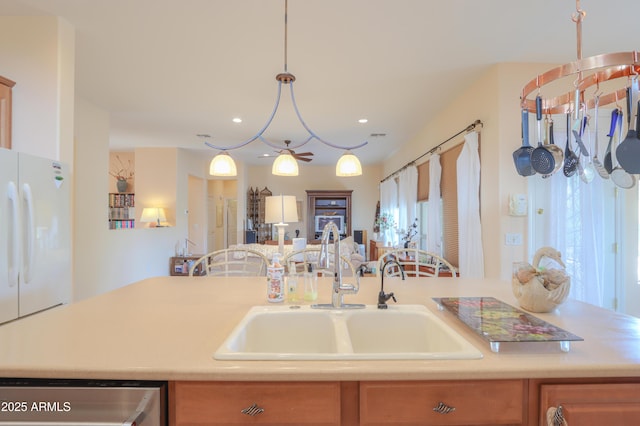 kitchen featuring freestanding refrigerator, light countertops, a sink, and stainless steel dishwasher