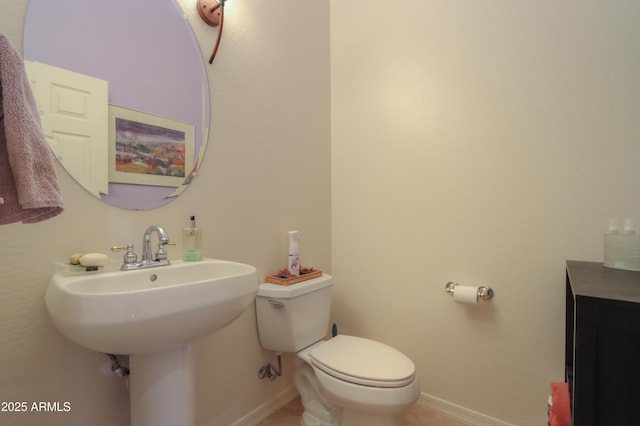 bathroom with tile patterned flooring, a sink, toilet, and baseboards