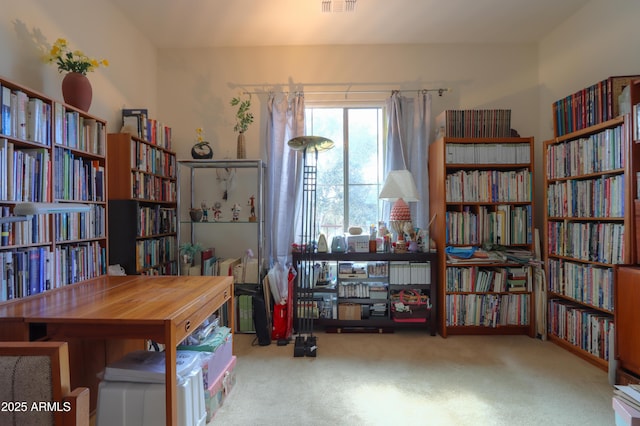 home office with bookshelves, carpet, and visible vents
