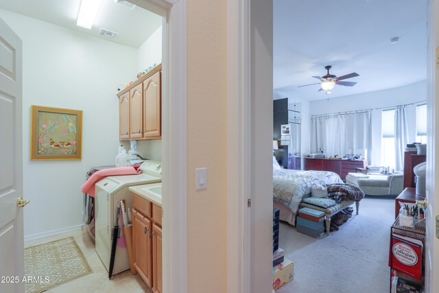 laundry room featuring ceiling fan, washing machine and dryer, visible vents, baseboards, and cabinet space