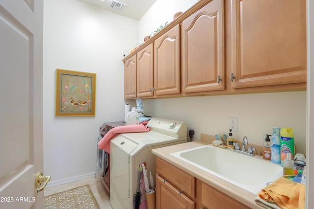 laundry room with visible vents, cabinet space, light tile patterned flooring, a sink, and separate washer and dryer