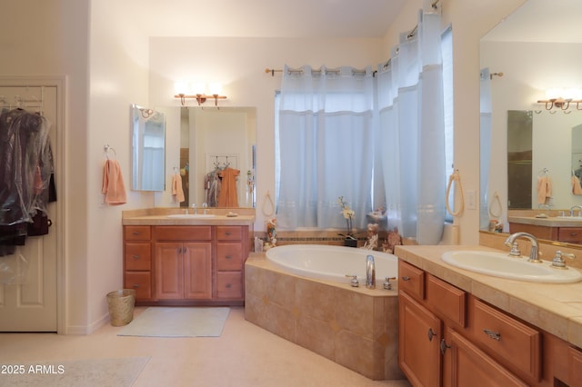 bathroom featuring a bath, two vanities, and a sink
