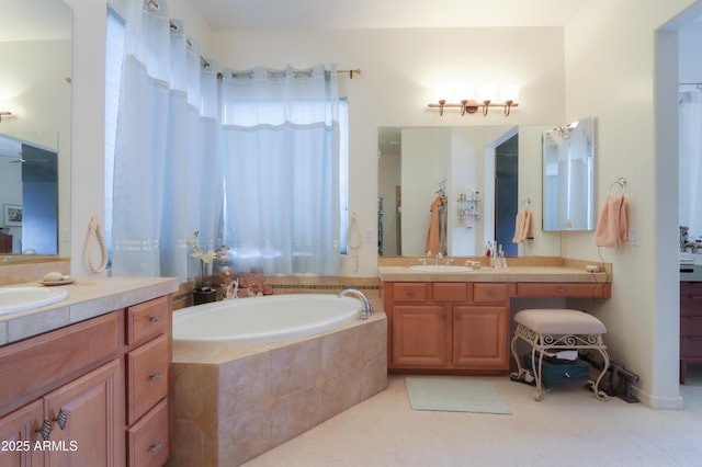 bathroom featuring two vanities, a sink, and a bath