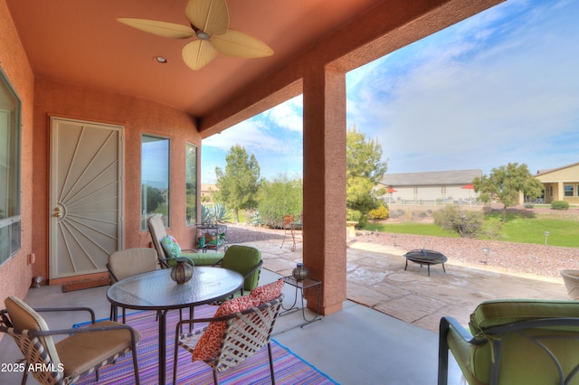 view of patio / terrace featuring ceiling fan and a fire pit