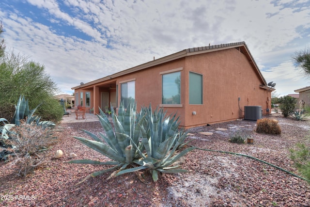 view of home's exterior with central air condition unit, a patio, and stucco siding