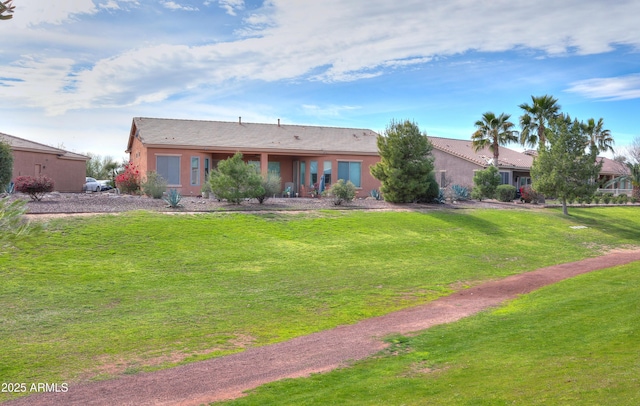 view of front of home featuring stucco siding and a front yard