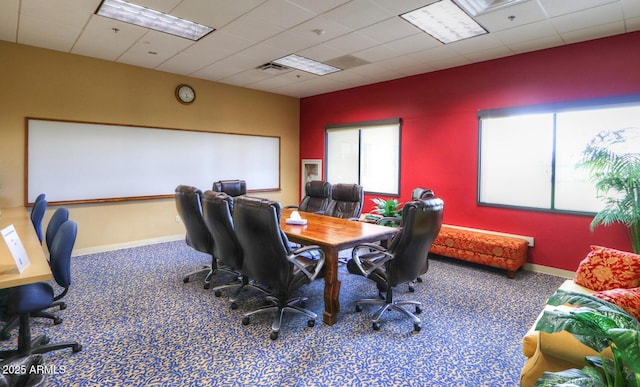 carpeted office space featuring a drop ceiling, visible vents, and baseboards