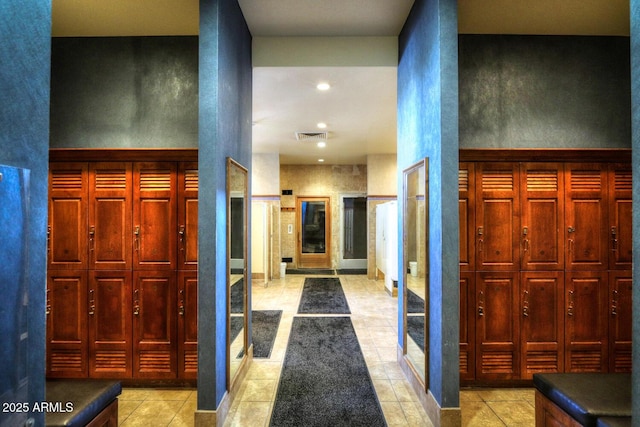 corridor with a towering ceiling, recessed lighting, visible vents, and light tile patterned flooring
