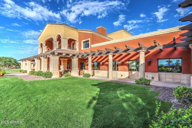 back of house with a lawn, a patio area, and stucco siding