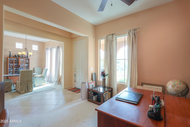 office space with ceiling fan with notable chandelier, plenty of natural light, and light tile patterned floors