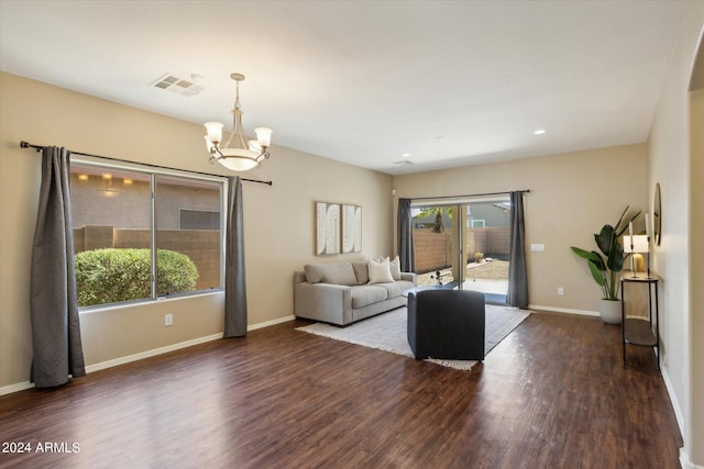 living room with a notable chandelier and dark hardwood / wood-style floors