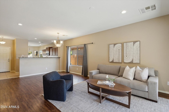 living room with light hardwood / wood-style flooring and an inviting chandelier