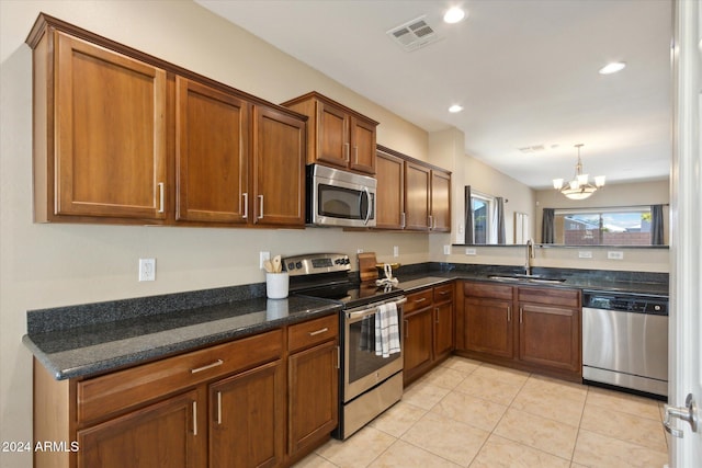 kitchen featuring dark stone countertops, sink, light tile patterned flooring, a chandelier, and appliances with stainless steel finishes