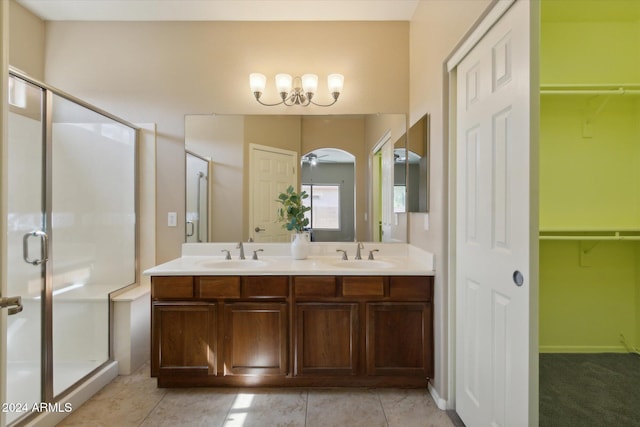 bathroom featuring a shower with door, vanity, ceiling fan, and tile patterned flooring