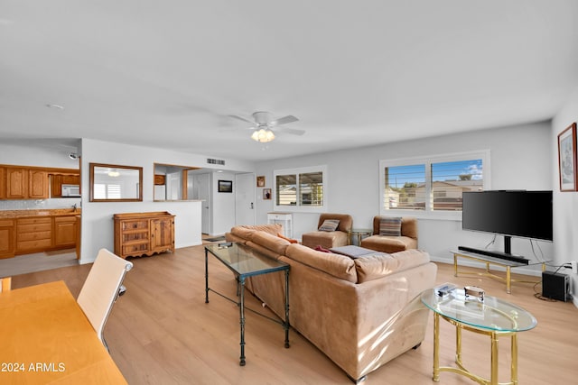 living room featuring light hardwood / wood-style flooring and ceiling fan