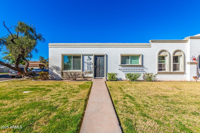 view of front of property with a front lawn and stucco siding