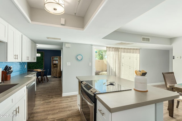 kitchen with appliances with stainless steel finishes, baseboards, wood finished floors, and white cabinetry