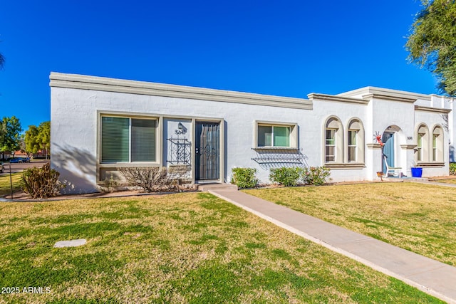 view of front of home with a front lawn and stucco siding