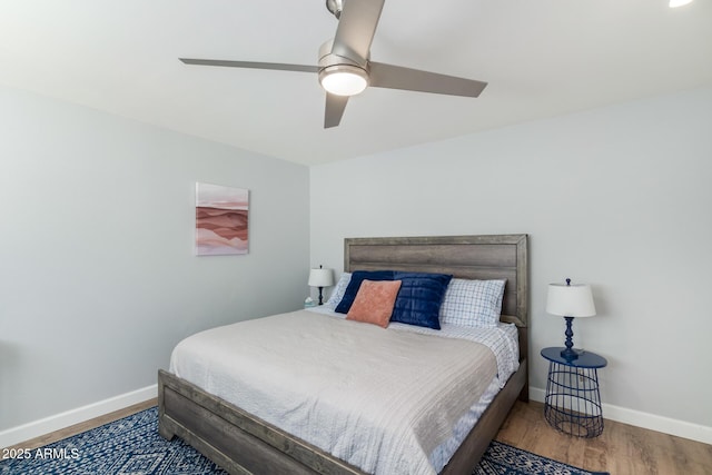 bedroom featuring baseboards, wood finished floors, and a ceiling fan