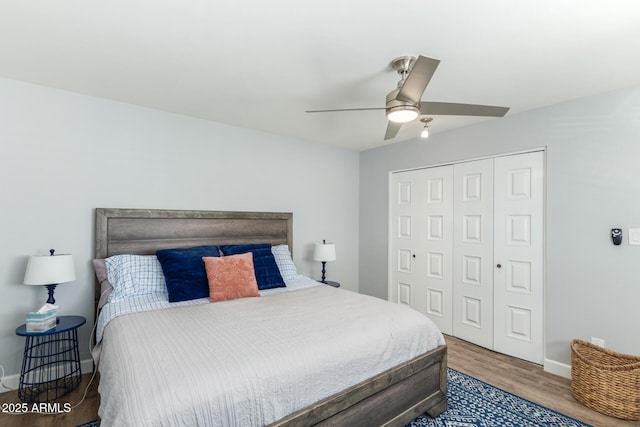 bedroom featuring wood finished floors, a closet, baseboards, and ceiling fan