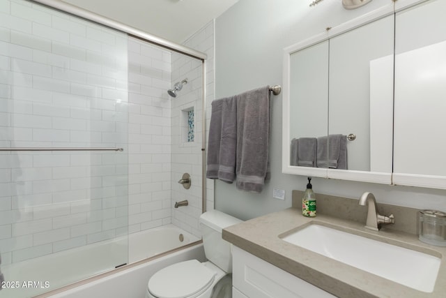bathroom with toilet, vanity, and enclosed tub / shower combo