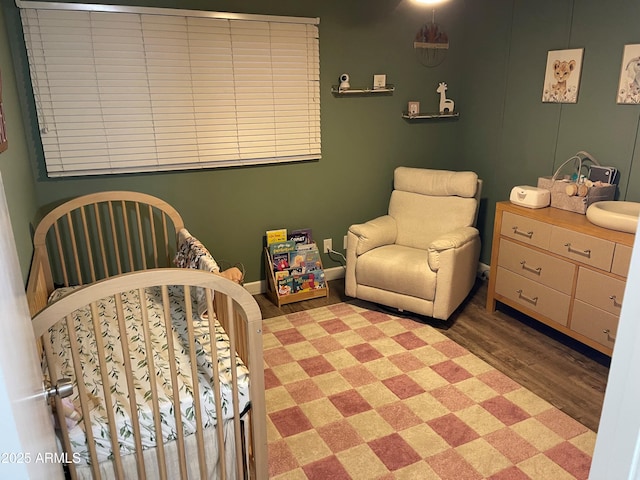 bedroom with wood finished floors and baseboards