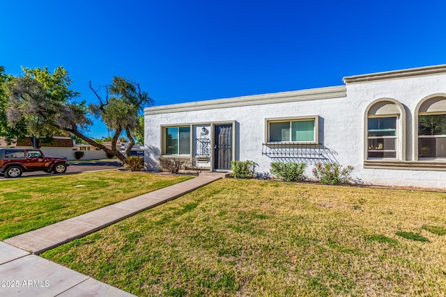 view of front of property featuring stucco siding and a front lawn