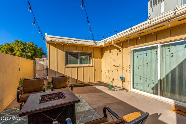 view of patio with an outdoor fire pit and fence
