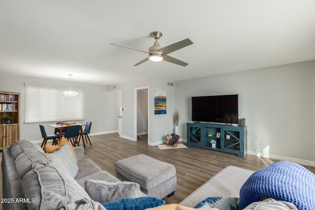 living room with wood finished floors, ceiling fan, and baseboards
