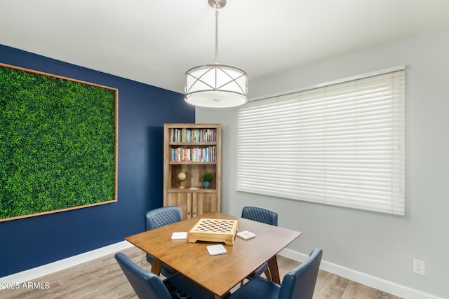 dining space with wood finished floors and baseboards