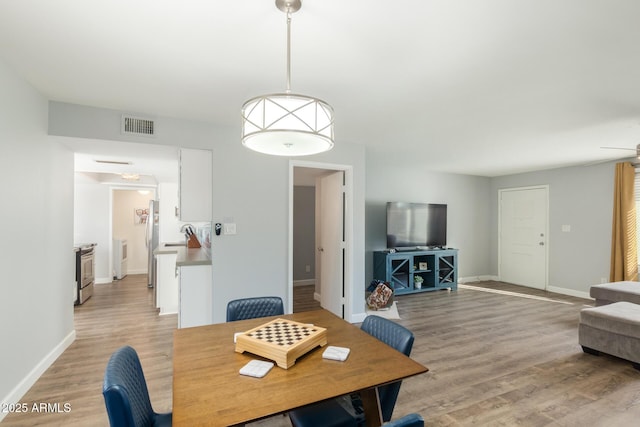 dining space featuring light wood-style floors and baseboards