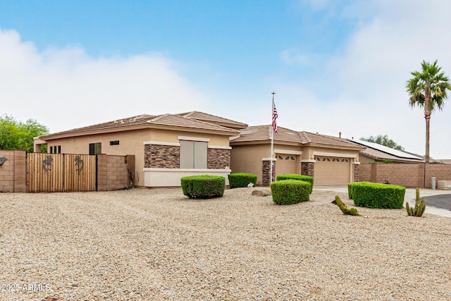 18247 N 168th Cir, Surprise, AZ 85374 - prairie-style house with stucco siding, an attached garage, fence, driveway, and stone siding