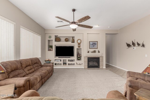18247 N 168th Cir, Surprise, AZ 85374 - carpeted living area with a ceiling fan, built in features, a fireplace, baseboards, and tile patterned floors