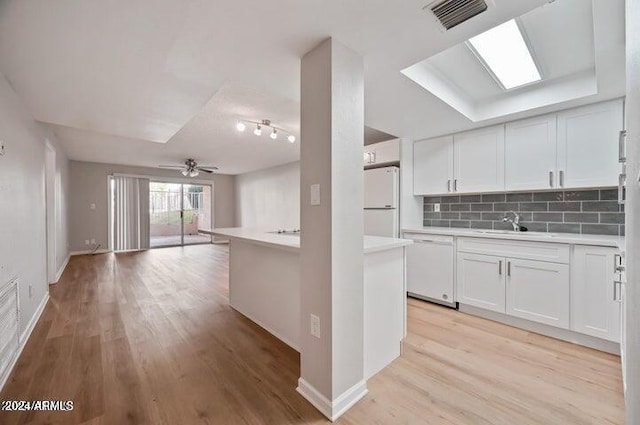 kitchen featuring light wood-type flooring, backsplash, white cabinets, and white appliances